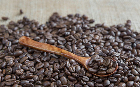 北欧风咖啡勺烤咖啡豆和木勺宏观棕色种子勺子食物麻布背景