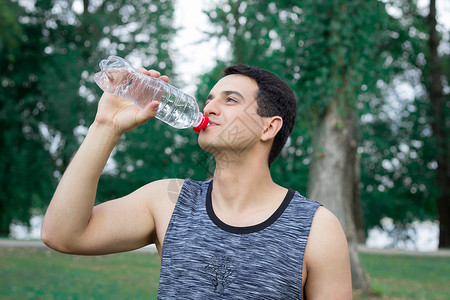 年轻健身男子在训练锻炼期间饮水背景图片