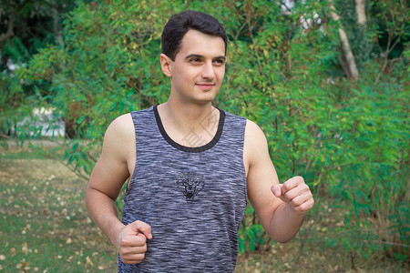 年轻健身男子在公园锻炼期间接受培训的年青健身人背景图片