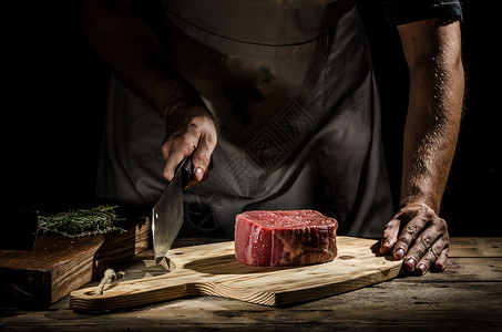 厨师屠夫准备牛肉牛排菜刀男性食物烹饪成人牛扒职业木板厨房广告背景图片