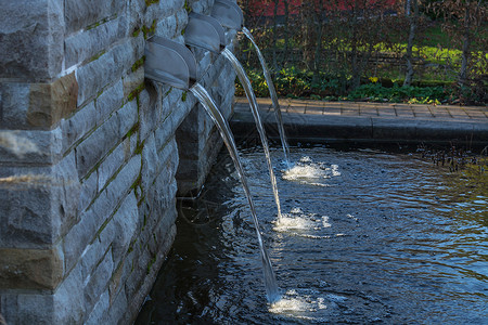 花园池塘的供水石墙水位溪流设计灌木场景庭园管道光源墙缝背景
