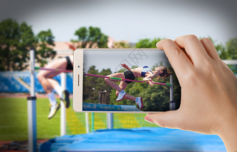 跳起来拍照女用智能手机照片摄影体育场博主女士屏幕技术女孩运动员竞赛相机背景