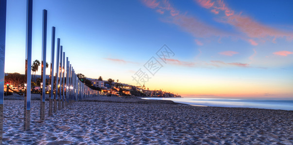 太阳升起在主海滩的镜像柱子上背景图片