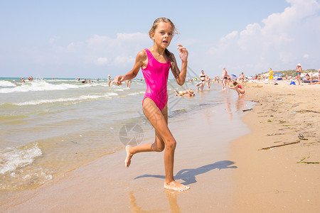 7岁女孩从海边的海滩上跑来跑去健康高清图片素材