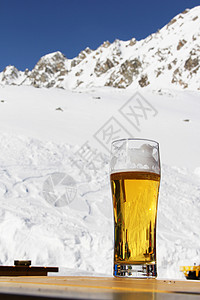 冬季山的啤酒咖啡店泡沫餐厅山脉滑雪酒精顶峰天空玻璃白色背景图片