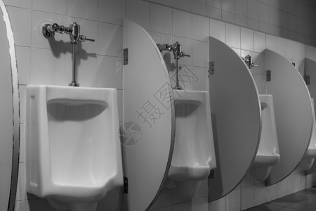 男厕所里有白色陶瓷小便和黄色亮光休息潮红奢华壁橱排尿阀门小便池瓷砖制品尿液背景