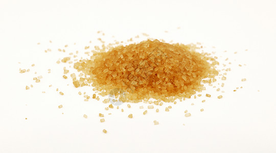 一片棕色甘蔗糖洒在白色上食物美食营养颗粒状黄色水晶背景图片