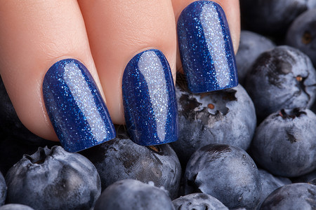 蓝色指甲油指甲化妆品美学广告凝胶卫生手指浆果背景图片