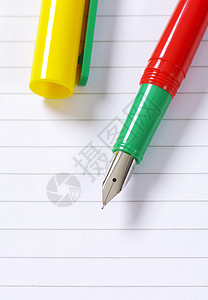 线纸上的钢笔书写校笔绿色工具床单笔尖空白高架红色横格背景图片