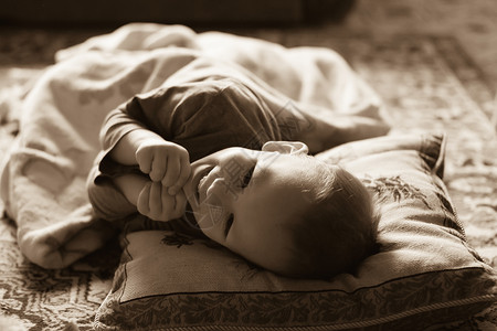 躺在床上欢笑的婴儿快乐脸高清图片素材