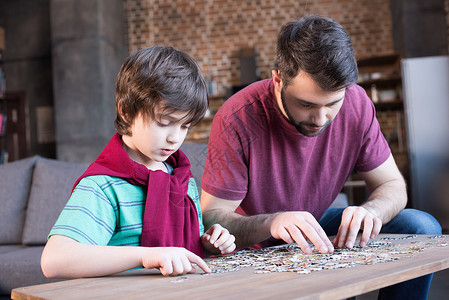 少年时代以父子为焦点的家庭游戏拼图的一面视图男生少年家庭父亲时代爸爸小学儿子孩子童年背景