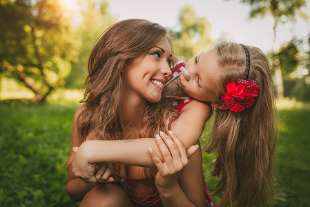 可爱的小女孩和她的妈妈女儿快乐公园休闲女士童年拥抱水平父母幸福春天高清图片素材
