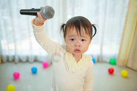 带麦克风的亚洲小女孩喜悦歌手情感乐趣歌曲女孩唱歌工作室童年房子背景图片