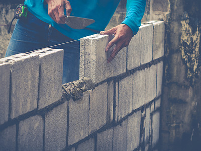 砖砖建工是建筑墙壁石匠房子石头石工工作男人水泥瓦工砖块工人背景图片