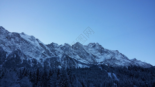 楚格峰山顶山景天雪蓝色山脉蓝天山地全景视图雪山背景图片