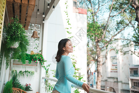 美丽的亚洲女孩享受着阳台上的清新福利假期女士呼吸露台生活空气酒店背景图片