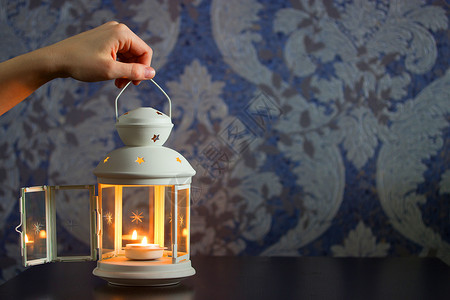 美丽的装饰灯笼或白铁蜡烛架壁灯蜡烛烛台玻璃白色女性星星背景图片