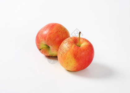 两个成熟苹果黄色水果食物红色背景图片