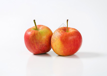 两个成熟苹果红色水果食物黄色背景图片