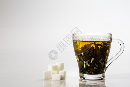 白色背景的茶杯中的茶 绿色或水果茶草本植物杯子餐具工作室橙子药品早餐盘子液体食物背景图片