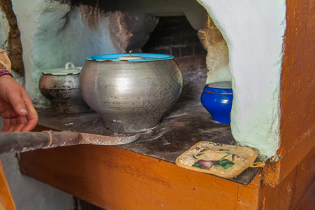 在俄罗斯炉灶中做饭国家盘子铸铁餐具面包乡村火焰平底锅房子炉石背景图片