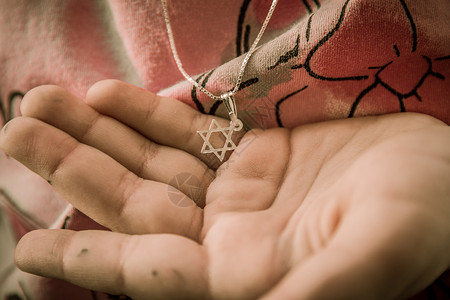星星吊坠一个女孩手上戴着大卫之星的领带皮肤金属手臂朋友信仰宗教手指奖章刺绣项链背景