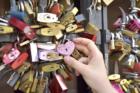 女孩手上的爱情锁巴塞尔瑞士2017 年 7 月 21 日挂锁艺术类情人夫妻栅栏栏杆钥匙旅行地标友谊背景