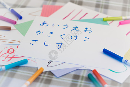 日语字符日语; 为练习写日文字母字符的孩子们背景