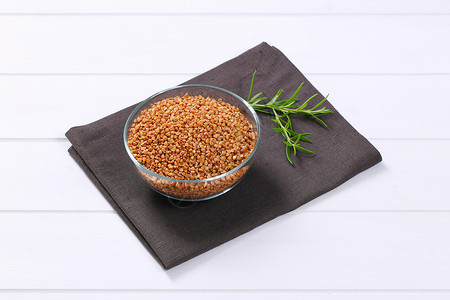 粗鲜的麦子碗碎粒伴奏白色餐垫灰色棕色谷物团体背景小菜背景图片