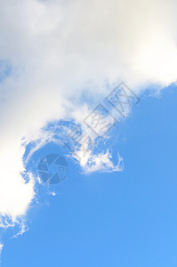 以浅蓝色天空和白色软云为底底 垂直背景图片