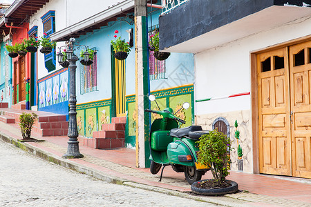 历史性摩托车在哥伦比亚安蒂奥基亚州Guatape的多彩城镇Guatape绿色摩托车假期历史性历史阳台街道底座遗产村庄城市殖民背景