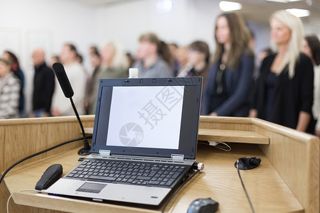 讲台上的讲台上满是会议与会者的演讲厅 有笔记本电脑和麦克风背景图片