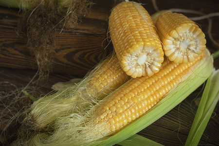 生锈木制餐桌上的鳕鱼上新鲜鲜甜玉米桌子蔬菜农业叶子植物粮食食物烹饪乡村木板背景图片