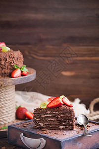木制背景中带草莓的俄罗斯巧克力蛋糕拿破仑糕点盘子面包薄荷美食咖啡糖果食物甜点烹饪背景图片