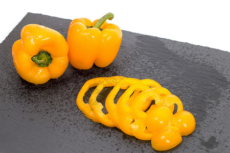黄黄胡椒食物黄色片岩石头胡椒蔬菜白色平板石板飞沫背景图片