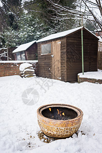 冬天我后院雪中的火碗冻结后院木棚季节花园加热房子冷冻壁炉火坑背景