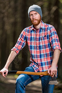 森林里一个身穿格子衬衣 带着斧头的男人的肖像高清图片