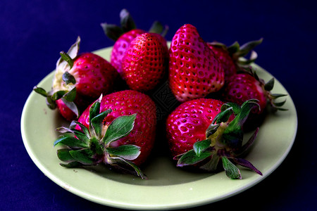 一大堆新鲜草莓在盘子里背景图片