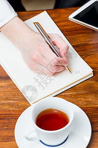 女性手在笔记本上用笔写一个字条女商务人士高清图片素材