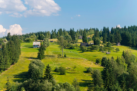 绿色山坡和蓝天背景下的零星小农村房屋面积之大;背景
