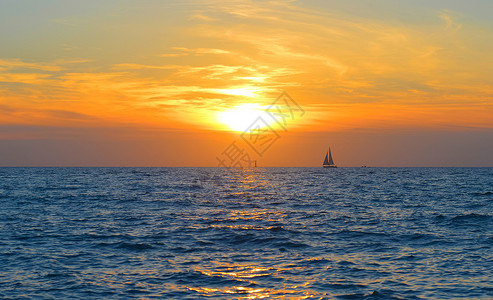 温暖日落帆船太阳海平面高清图片