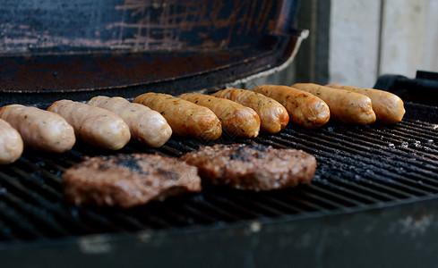 牛肉汉堡和香肠在公开的烤炉上做饭背景图片