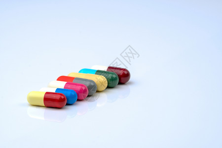 五颜六色的抗生素胶囊药丸在白色背景上排成一行 带有复制空间 耐药 抗生素用药合理 卫生政策和医保理念 医药行业 药房背景胶囊蓝色背景图片