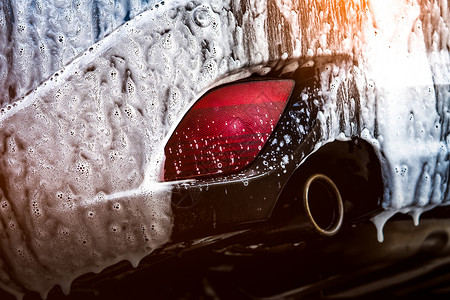具有运动和现代设计的蓝色紧凑型 SUV 汽车用肥皂洗涤 用白色泡沫盖的汽车 汽车护理服务经营理念 玻璃打蜡和玻璃涂层汽车前用泡沫湿的高清图片素材