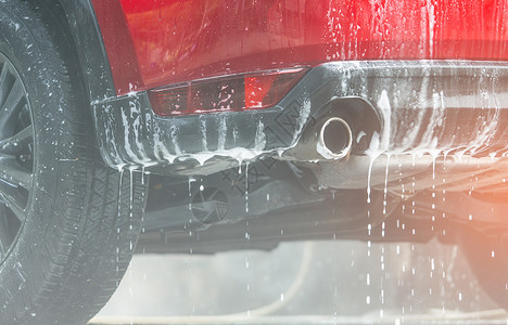 汽车镀膜具有运动和现代设计的红色紧凑型 Suv 汽车用肥皂洗涤 用白色泡沫盖的汽车 汽车护理服务经营理念 玻璃打蜡和玻璃镀膜汽车前用泡沫背景