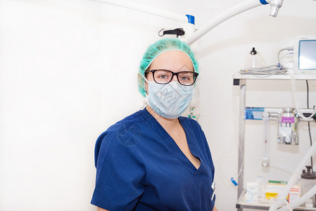 手术室内戴面罩护士肖像女性女士医生快乐工作诊所外科专家医院蓝色面具高清图片素材