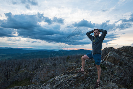 站在悬崖顶上的男人生活顶峰男性冒险石头现实旅游领导游客胜利宁静高清图片素材