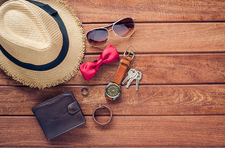 木地板上男士的配饰和服装  生活方式裤子太阳镜旅行帽子背景图片