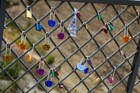 墙上有许多色彩多彩的爱情挂锁忠诚金属文化钥匙安全誓言栅栏友谊红色背景图片