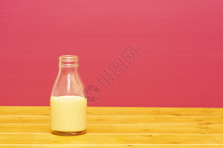 玻璃牛奶瓶半满 加香蕉奶昔高清图片